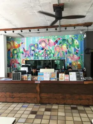 a restaurant with a counter with a person behind it at Apartments in The Title Beach Rawai in Rawai Beach
