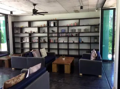 a living room with couches and a book shelf at Apartments in The Title Beach Rawai in Rawai Beach