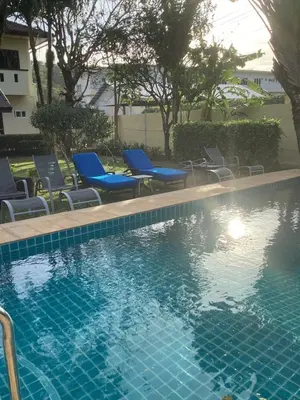 a swimming pool with blue lounge chairs and a swimming pool at Bann Jai Dee in Nai Yang Beach