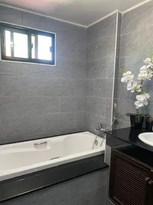 a bathroom with a white bath tub and a sink at Bann Jai Dee in Nai Yang Beach