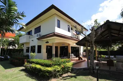 a large white house with a yard at Bann Jai Dee in Nai Yang Beach
