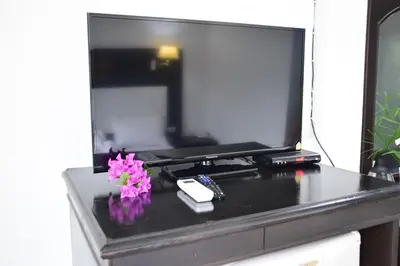 a black table with a tv and flowers on it at Wan Wan Place in Ao Nang Beach