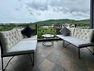 a balcony with two white couches and a table at Klong Muang Beach Apartment in Klong Muang Beach