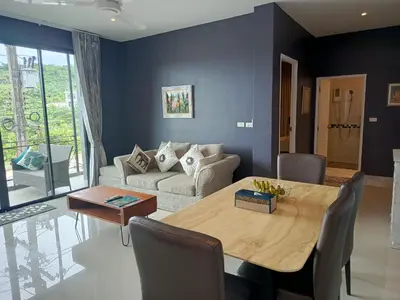 a living room with a table and a couch at Klong Muang Beach Apartment in Klong Muang Beach