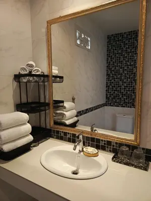 a bathroom with a sink and a mirror and towels at Klong Muang Beach Apartment in Klong Muang Beach