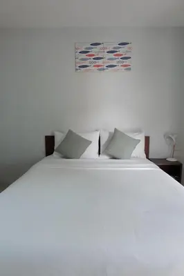 a white bed with pillows and a painting on the wall at 3B Apartment-SHA Extra Plus in Kamala Beach