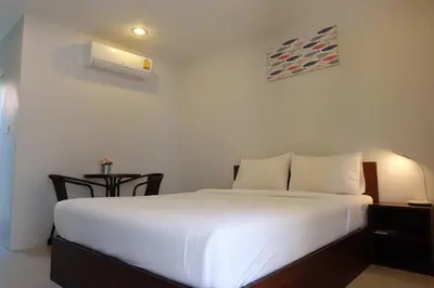 a bedroom with a white bed and a desk with a lamp at 3B Apartment-SHA Extra Plus in Kamala Beach