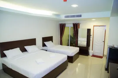 a hotel room with two beds and a television at Smile Residence in Rawai Beach
