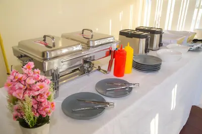 a table with plates and utensils and flowers on it at Smile Residence in Rawai Beach