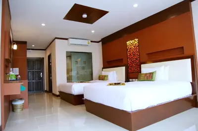 a hotel room with two beds and a bathroom at Chivatara Resort Bang Tao Beach Phuket - SHA in Bang Tao Beach