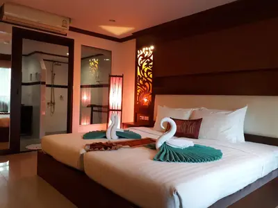 a bedroom with a large bed with swans on it at Chivatara Resort Bang Tao Beach Phuket - SHA in Bang Tao Beach