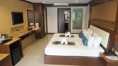 a hotel room with a bed and a television at Chivatara Resort Bang Tao Beach Phuket - SHA in Bang Tao Beach