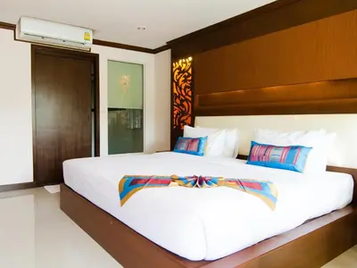 a bedroom with a large white bed with a wooden headboard at Chivatara Resort Bang Tao Beach Phuket - SHA in Bang Tao Beach
