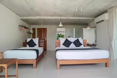 a bedroom with two beds and a table at Wabi Sabi Boutique Hotel - SHA Extra Plus in Kamala Beach