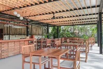 an outdoor restaurant with wooden tables and chairs at Wabi Sabi Boutique Hotel - SHA Extra Plus in Kamala Beach