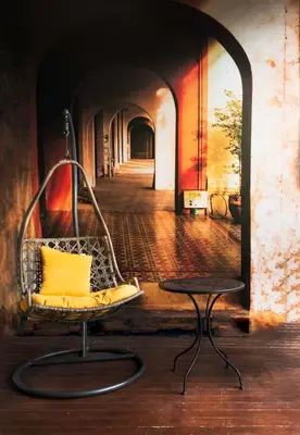 a chair with a yellow pillow in a hallway at 217@HKT in Phuket Town