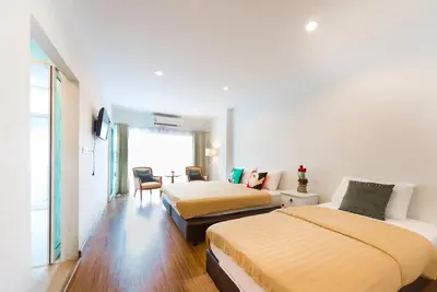 a hotel room with two beds and a couch at 217@HKT in Phuket Town