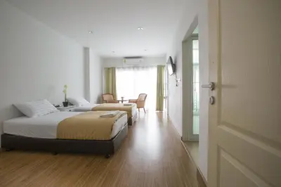 a bedroom with two beds and a table and chairs at 217@HKT in Phuket Town