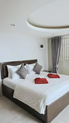a bedroom with a large bed with two red pillows at Naiyang Seaview Place Resort in Nai Yang Beach
