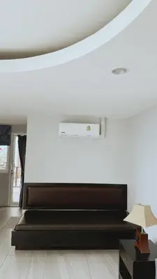 a white room with a black bed and a white wall at Naiyang Seaview Place Resort in Nai Yang Beach
