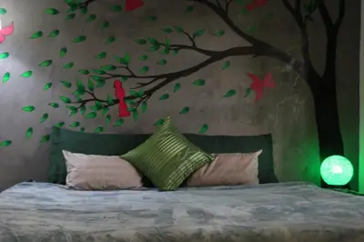 a bedroom with a tree with red birds on the wall at 1715 House - White Rhino in Rawai Beach