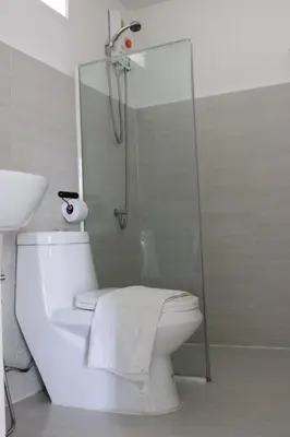 a white bathroom with a shower and a toilet at 1715 House - White Rhino in Rawai Beach