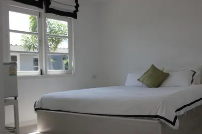 a white bed in a room with a window at 1715 House - White Rhino in Rawai Beach