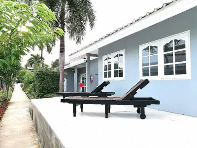 a house with two benches in front of it at 1715 House - White Rhino in Rawai Beach