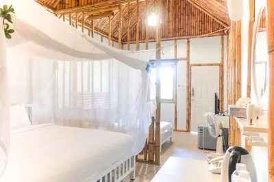 a bedroom with a bed with a mosquito net at Anyavee Krabi Beach Resort in Klong Muang Beach