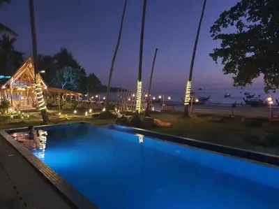 a blue swimming pool at night with a beach at Anyavee Krabi Beach Resort in Klong Muang Beach