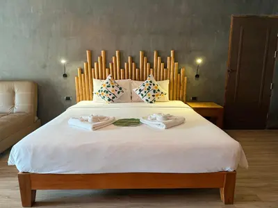 a bedroom with a large bed with two towels on it at Anyavee Krabi Beach Resort in Klong Muang Beach