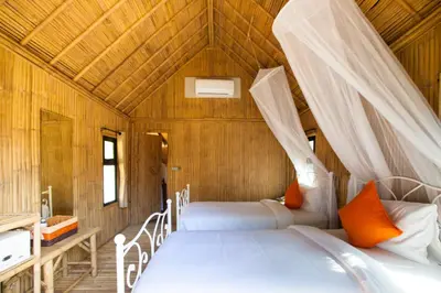 a bedroom with two beds in a wooden house at Anyavee Krabi Beach Resort in Klong Muang Beach