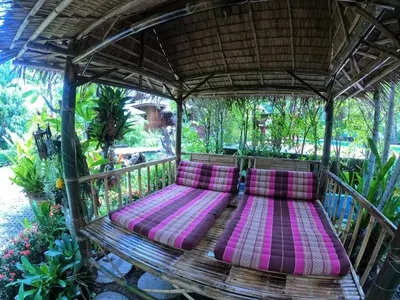 a bench in a gazebo with pink pillows at Cozy Garden Resort in Ao Nang Beach