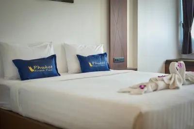 a stuffed animal is laying on a bed at Phuket Airport Place in Nai Yang Beach