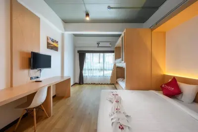 a room with a bed and a desk and a computer at Phuket Airport Place in Nai Yang Beach