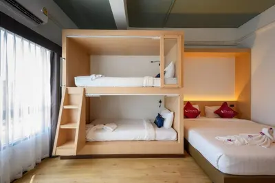 two bunk beds in a room with a window at Phuket Airport Place in Nai Yang Beach