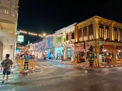 a city street at night with people walking down the street at Chino Town at Yaowarat Phuket - SHA Plus in Phuket Town