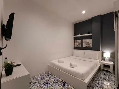 a bedroom with a white bed with a black wall at Chino Town at Yaowarat Phuket - SHA Plus in Phuket Town