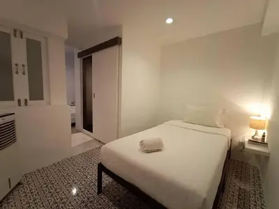 a bedroom with a white bed with a hat on it at Chino Town at Yaowarat Phuket - SHA Plus in Phuket Town