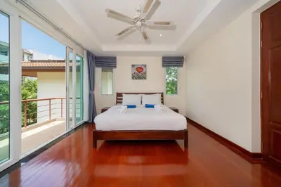a bedroom with a bed and a ceiling fan at Baan Kaja Villa by Lofty in Surin Beach