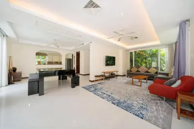 a living room with a red couch and a piano at Baan Kaja Villa by Lofty in Surin Beach