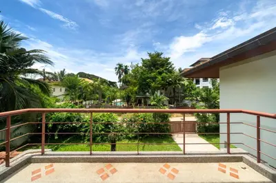 a balcony with a view of trees and buildings at Baan Kaja Villa by Lofty in Surin Beach