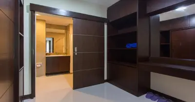 a bathroom with a wooden closet with a mirror at The Lai Thai Luxury Condominiums in Ao Nang Beach