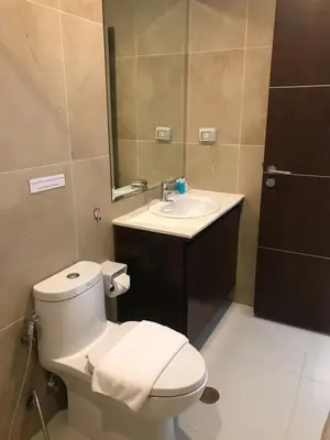 a bathroom with a toilet and a sink and a mirror at The Lai Thai Luxury Condominiums in Ao Nang Beach