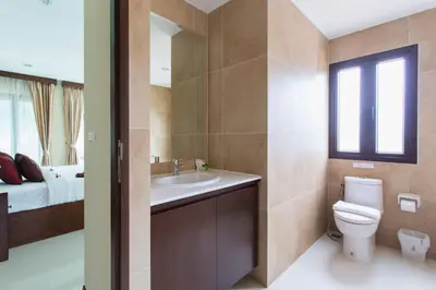 a bathroom with a sink and a toilet and a bed at The Lai Thai Luxury Condominiums in Ao Nang Beach