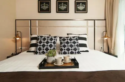 a bed with black and white pillows and a tray on it at The Title KR Beach Condotel Rawai Beach in Rawai Beach