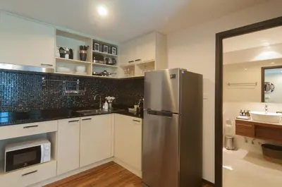 a kitchen with a stainless steel refrigerator and a sink at The Title KR Beach Condotel Rawai Beach in Rawai Beach