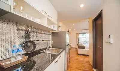 a kitchen with a sink and a refrigerator at The Title KR Beach Condotel Rawai Beach in Rawai Beach