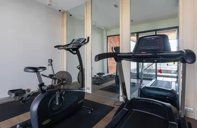 a room with a gym with a treadmill and a bike at Recenta Style Phuket Town in Phuket Town