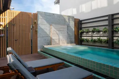 a swimming pool with a chair next to a building at Recenta Style Phuket Town in Phuket Town
